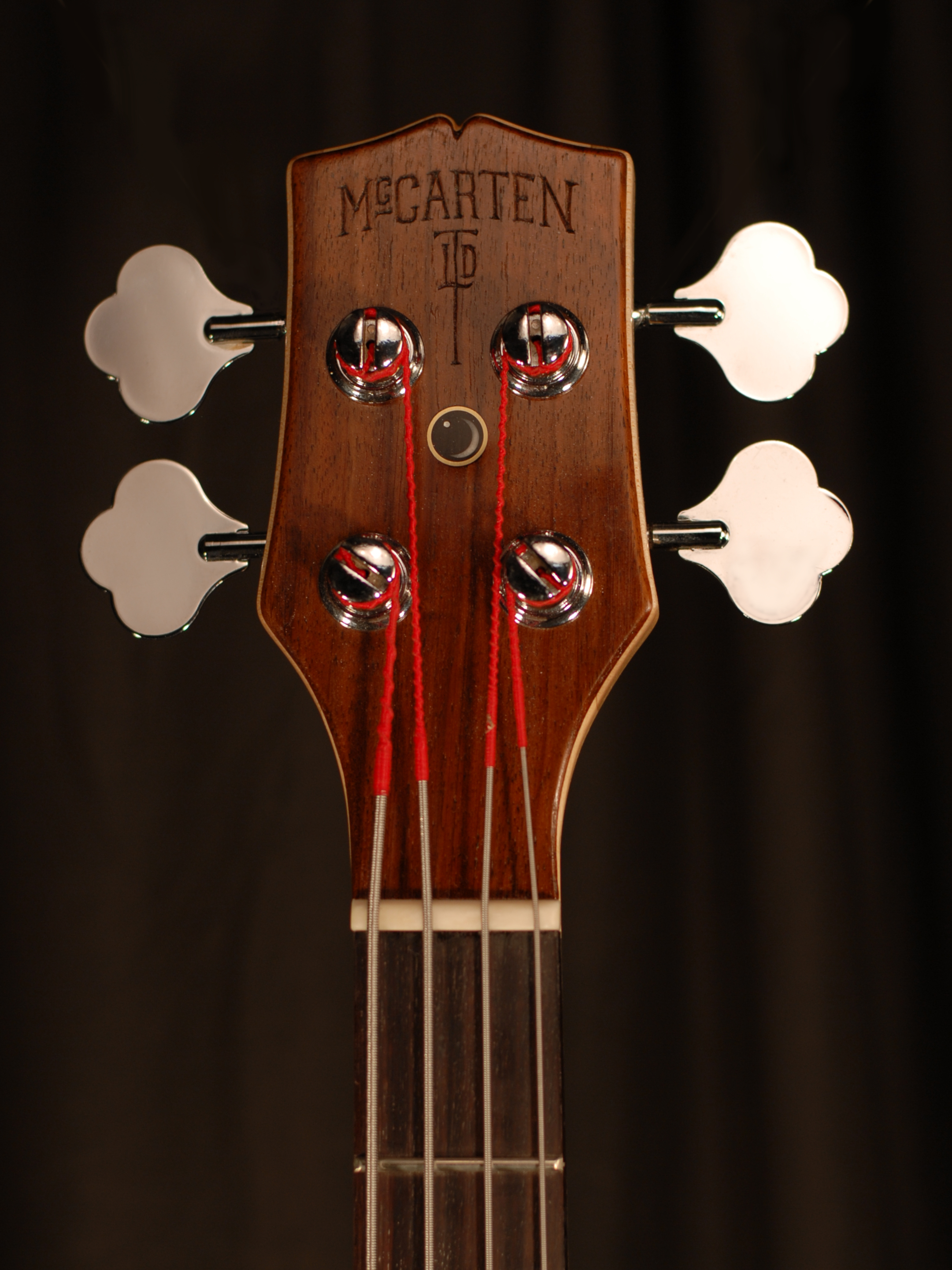 front view of the headstock of michael mccarten's double cutaway electric bass guitar model